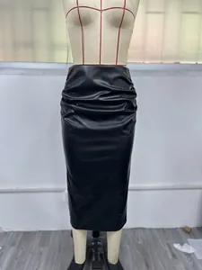 Détail rapproché de la jupe midi moulante en similicuir noir avec des fronces