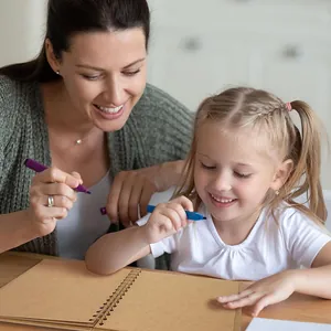 Mother and daughter creating memories in a vintage DIY brown kraft scrapbook album