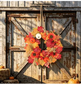 Couronne d'automne vibrante avec feuilles d'érable et citrouilles sur porte de grange