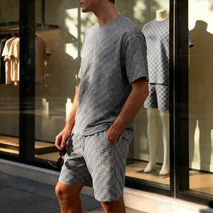 Grijze jacquard schaakbord herenset met T-shirt en korte broek in een straatomgeving