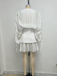 Vista trasera de un minivestido blanco de malla con mangas rizadas y pliegues