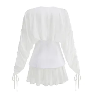 Vista trasera del minivestido blanco de malla de manga larga con cintura de corsé