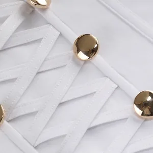 Detalle macro de vestido blanco con elegante diseño de cordones y botones dorados pulidos