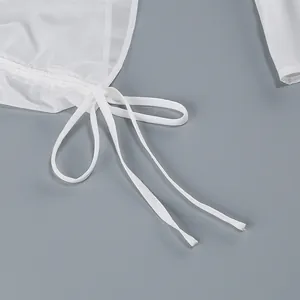 Primer plano de vestido de verano de malla blanca con textura fruncida y detalle de lazo ajustable