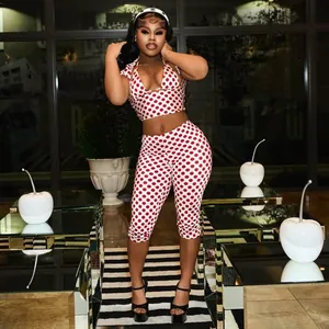 Fashionable woman wearing a red and white polka dot halter top and matching capri pants