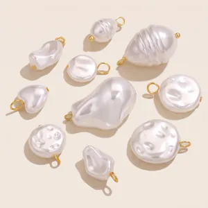 Macro view of assorted irregular imitation pearl charms with gold-plated metal loops