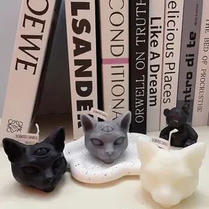 Handmade three-eyed cat scented candles in black, white, and grey for gothic Halloween decor