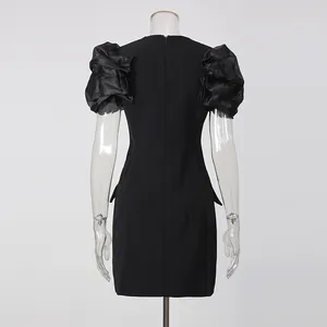 Detailed back view of a chic black blazer dress featuring elegant ruffled puff sleeves.