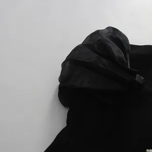 Close-up detail showing the pleated puff sleeve design on an elegant black suit dress