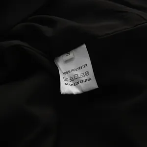 Detail showing the care label and 100% polyester fabric composition of the blazer dress