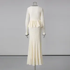 Vista trasera de un vestido largo de encaje crema con cintura peplum y dobladillo sirena.