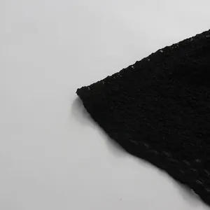 Detalle de cerca de la tela texturizada negra con borde ondulado de un vestido