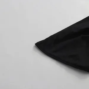 Detalle del dobladillo ondulado en un vestido negro de estilo francés con corte sirena