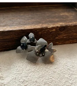 Nahaufnahme einer Vintage-Brosche aus antikem Silber mit Natursteinen und Kristallen