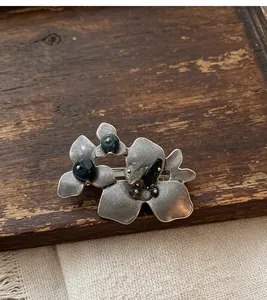 Detailansicht einer Vintage-Brosche aus Altsilber-Blatt mit Naturstein-Verzierungen