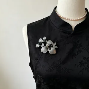 Eleganter Vintage-Blumenbrosche aus Altsilber mit Natursteinen auf schwarzem Qipao