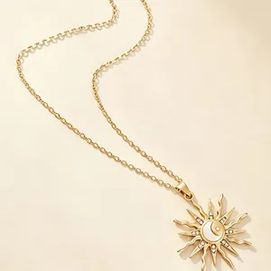 Close-up detail of golden sun and moon pendant necklace with rhinestone accents