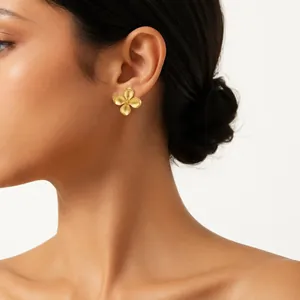 Elegant detail shot of a vintage French style gold flower stud earring worn by a model