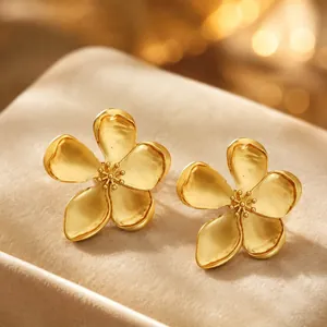 Close-up of vintage French style gold flower earrings with matte textured petals