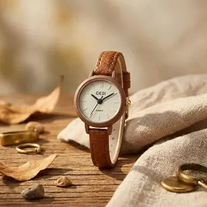 GEDI vintage women's quartz watch with slim brown leather strap displayed on a wooden surface
