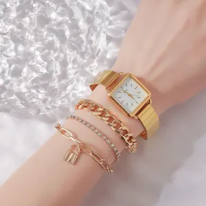 Detail view of a 4pcs vintage gold square watch and chain bracelet set on wrist
