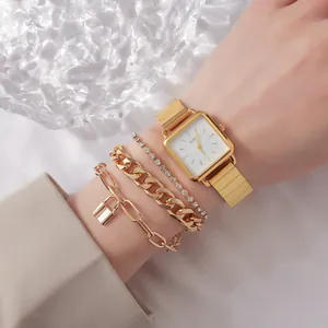 Close-up of elegant vintage gold square watch paired with a stylish stacked bracelet set on wrist