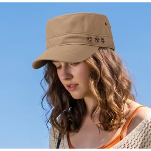 Détail d'une casquette militaire kaki avec étoiles en métal sur fond de ciel bleu.