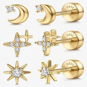 Close-up of mini gold-plated celestial earrings with moon and starburst designs