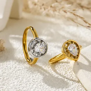 Elegant gold-tone rings featuring clear round and pear-cut cubic zirconia stones in sunlight