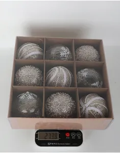 Close-up weighing display of a 9-piece set of decorative Christmas baubles in box