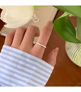Detailansicht eines minimalistisch gehämmerten Silberrings am Zeigefinger in Lifestyle-Szene