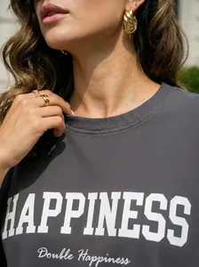 Detalle de una camiseta de algodón gris oscuro con el eslogan Happiness impreso en blanco