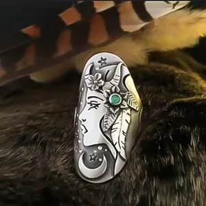 Detailed macro view of a vintage silver ring featuring engraved face and turquoise stone