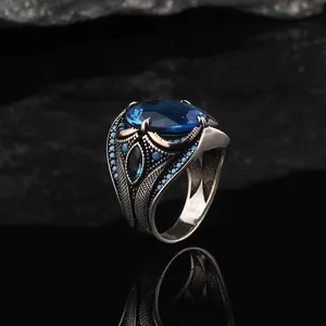 Detailed macro view of vintage men's silver ring featuring a large oval blue gemstone