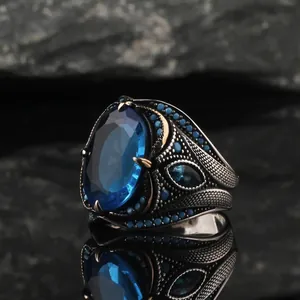 Detailed macro shot of a vintage men's ring featuring a large oval blue gemstone
