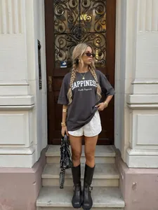 Detalle de una camiseta oversize de algodón gris con estampado Happiness llevada por una modelo