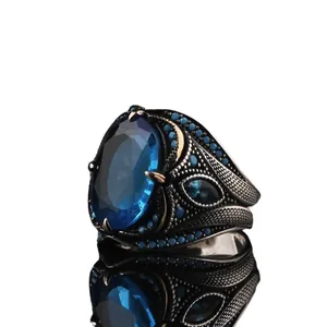 Vintage men's ring featuring a large blue oval zircon and intricate silver scrollwork