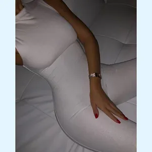 Detailopname van een witte mouwloze nauwsluitende jumpsuit met focus op de stof en pasvorm