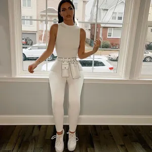 Detail van een witte mouwloze jumpsuit met hoge taille en bijpassende heuptas set