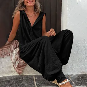 Λεπτομερής λήψη μαύρης αμάνικης ολόσωμης φόρμας με κουκούλα, κουμπιά και ανάγλυφη υφή.