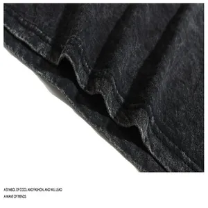 Macro detail of acid-washed black cotton fabric showing high-quality stitching and texture.