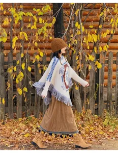 Poncho en tricot style bohème avec franges et motifs ethniques dans un décor d'automne