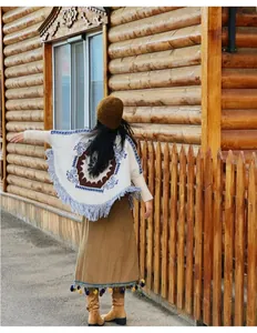 Vue arrière d'un poncho en maille bohème à franges et motifs ethniques en extérieur