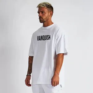 Model draagt een wit oversized katoenen fitness T-shirt met Vanquish-print op de borst