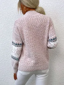 Back view of a soft pink knitted sweater featuring snowflake patterns on the sleeves
