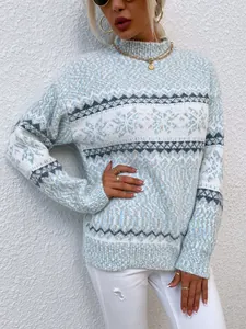 Detail view of women's mock neck knit sweater featuring blue and white snowflake pattern