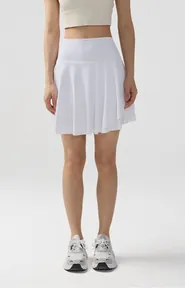 Vista frontal de una modelo con falda deportiva plisada blanca para tenis y gimnasio