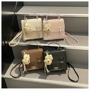 Four stylish college-style mini backpacks with teddy bear charms on stairs