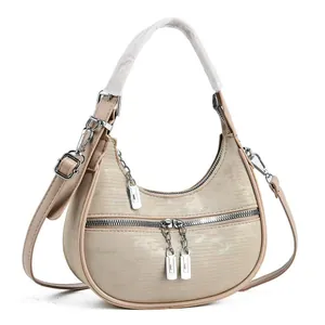 Detailed front view of a champagne hobo bag featuring textured finish and silver hardware