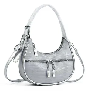 Close-up of silver crescent hobo bag with metallic ribbed texture and double zippers